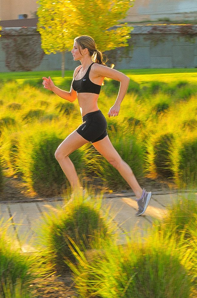 Woman running amongst grassy LA street in Fitness Photo Shoot